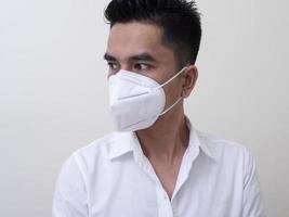 Asian young man in white shirt and medical mask to protect COVID-19 photo