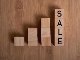 Wooden cubes with word SALE on blue table photo