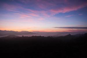 montaña de niebla en la salida del sol temprano en la mañana foto