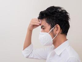 Asian young man in white shirt and medical mask to protect COVID-19 photo