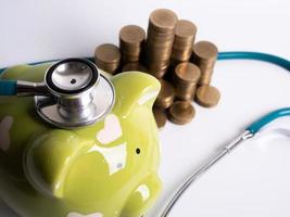 piggy bank with coins and stethoscope photo