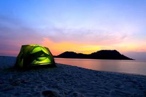 green tent on beach in sunset photo