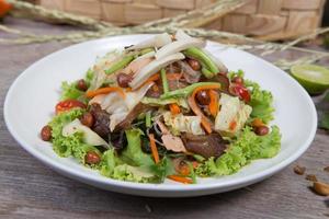 Ensalada thai con zanahoria, tomate, fideos de vidrio, apio y cerdo foto