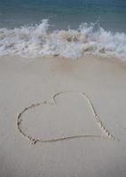 hearts drawn on the sand of a beach photo