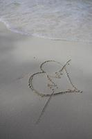 corazones dibujados en la arena de una playa foto