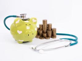 piggy bank with coins and stethoscope photo