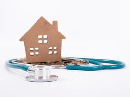 Check up house and investment concept. Stethoscope with miniature house and money photo