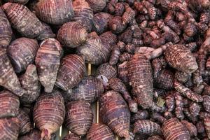 pile of taro for retail sale in local market. background of fresh taro. photo