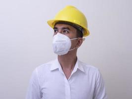 Asian industrial workers wear yellow hard hats, wear protective masks for their health photo