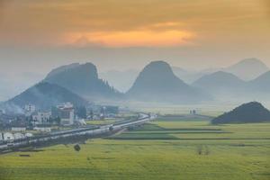 Yellow rapeseed flower field with the mist in Luoping, China photo