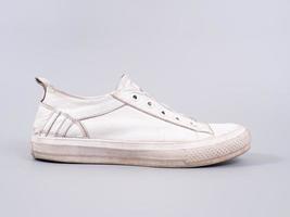 Old white sneaker on a gray background photo