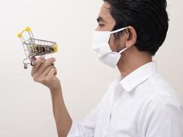 Man holding a shopping cart filled with gold coins photo