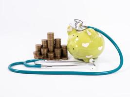 piggy bank with coins and stethoscope photo