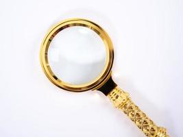 Small Gold Magnifying Glass Isolated on a White Background. photo