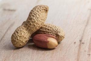 peanuts in shells over wood background photo