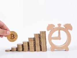 Hand Holding Bitcoin and many coin and clock for saving money concept on white background photo