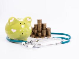 piggy bank with coins and stethoscope photo