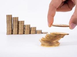 Hand put coins to stack of coins on white background photo