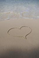 hearts drawn on the sand of a beach photo