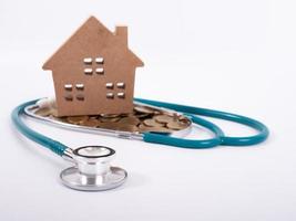 Check up house and investment concept. Stethoscope with miniature house and money photo