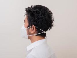 Asian young man in white shirt and medical mask to protect COVID-19 photo