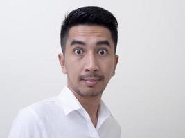 Shocked face of Asian man in white shirt on white background. photo