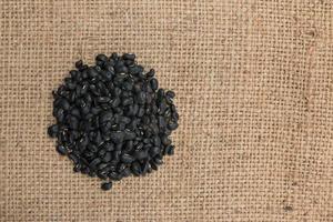 Black turtle beans on on sack background. photo