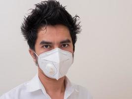 Asian young man in white shirt and medical mask to protect COVID-19 photo