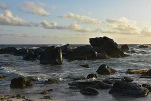 Sun Shining on Rocks in the Ocean in Aruba photo