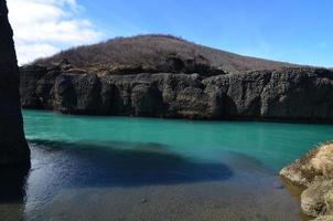 gran colina en islandia con un río que fluye debajo foto