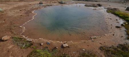 Resting geysir in Iceland with mineral deposits photo