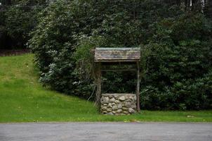 Rustic Wood and Stone Wishing Well on a Farm photo