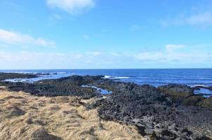 aguas serenas del océano azul a lo largo de la costa de islandia foto