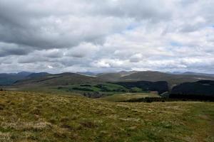 Thick Gray Clouds Over  Rolling Hills and Mountains photo