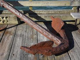 Rusted Ship's Anchor on a Pier in a Harbor photo