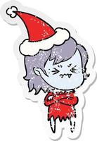 annoyed distressed sticker cartoon of a vampire girl wearing santa hat vector