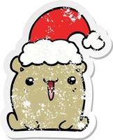 distressed sticker of a cute cartoon bear with christmas hat vector