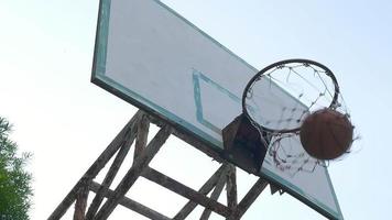 slow motion av mannen som skjuter basket i bågen gör den framgångsrika poängen video