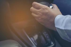 Man driving car while holding automatic gear shift control photo