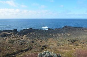 vista panorámica de la costa de rocas de lava negra en islandia foto