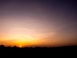 silueta puesta de sol sobre el campo de arroz foto