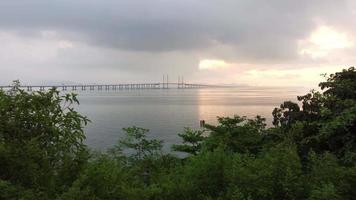 Slow move over green tree toward Penang Second Bridge in morning video