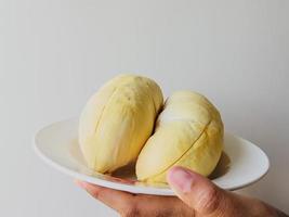 joven asiática sosteniendo durian en un plato foto