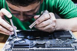 Man fixing laptop computer - technology computer reparing concept photo