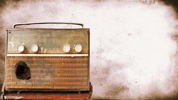 A very old, damaged radio player with an old picture background. photo