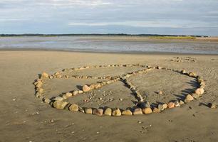 Peace Symbol on a Beach Made Out of Rocks photo