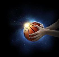 pelota de baloncesto en la mano del hombre. concepto de juego de baloncesto foto