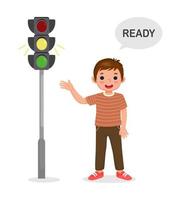 cute little boy showing traffic light indicator yellow light on vector