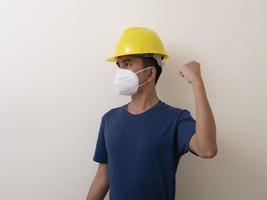 Asian industrial workers wear yellow hard hats, wear protective masks for their healtha photo
