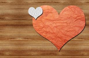 two paper hearts on a wooden wall photo